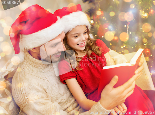 Image of smiling father and daughter reading book