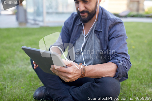 Image of close up of man with tablet pc and earphones