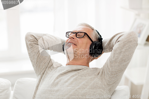Image of happy man in headphones listening to music at home
