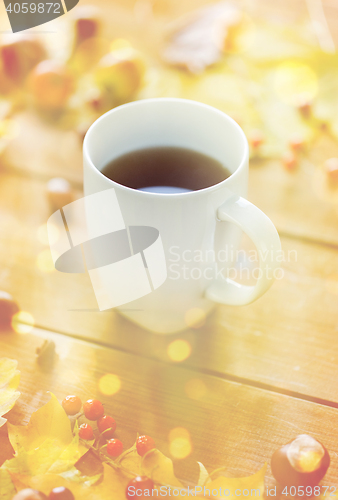 Image of close up of tea cup on table with autumn leaves