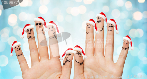 Image of close up of fingers with smiley in santa hats