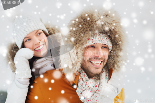 Image of happy couple having fun over winter background