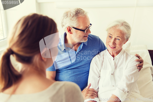 Image of happy family visiting senior woman at hospital