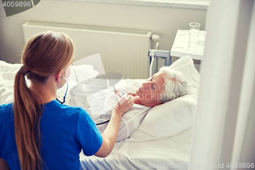 Image of nurse with stethoscope and senior woman at clinic