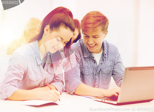 Image of students with laptop and notebooks at school