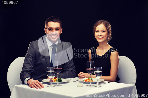 Image of smiling couple eating main course at restaurant