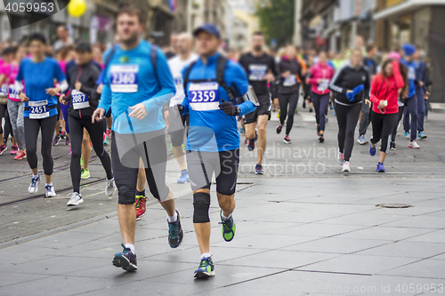 Image of Marathon runners race in city streets, blurred motion