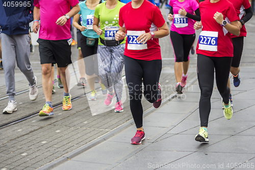 Image of Marathon runners race in city streets, blurred motion