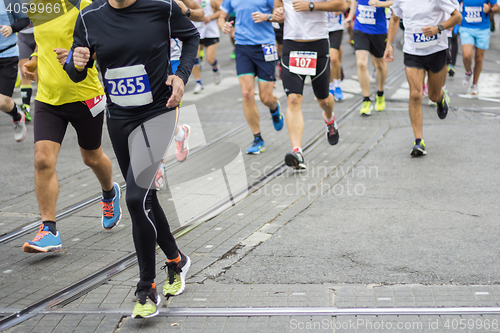 Image of Marathon runners race in city streets, blurred motion