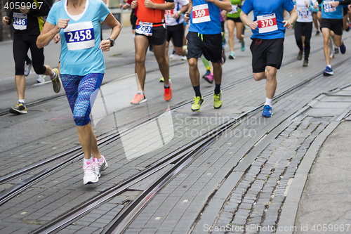 Image of Marathon runners race in city streets, blurred motion