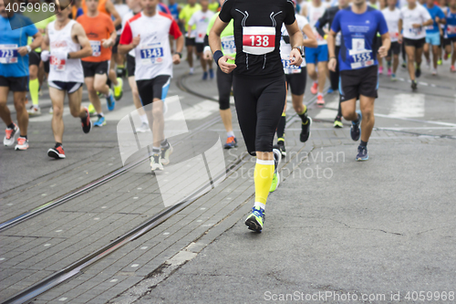 Image of Marathon runners race in city streets, blurred motion