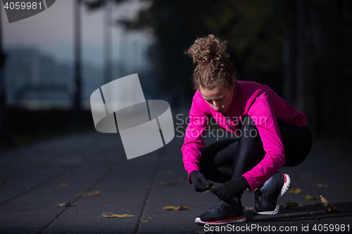 Image of woman  stretching before morning jogging