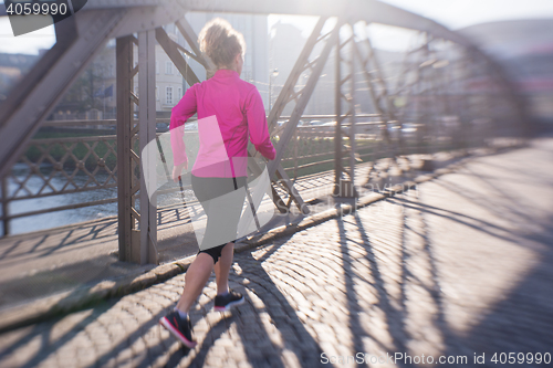 Image of sporty woman jogging on morning