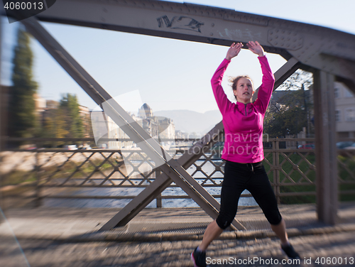 Image of woman  stretching before morning jogging