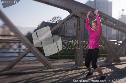 Image of woman  stretching before morning jogging