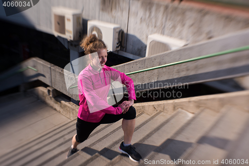 Image of woman  stretching before morning jogging