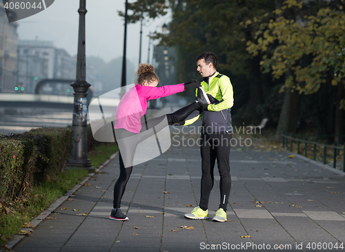 Image of couple warming up before jogging