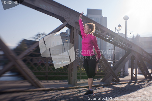 Image of woman  stretching before morning jogging