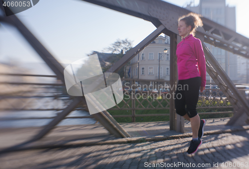 Image of woman  stretching before morning jogging