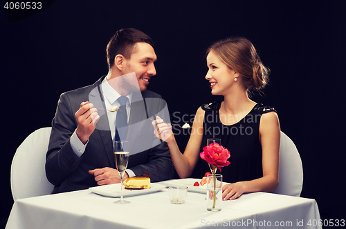Image of smiling couple eating dessert at restaurant