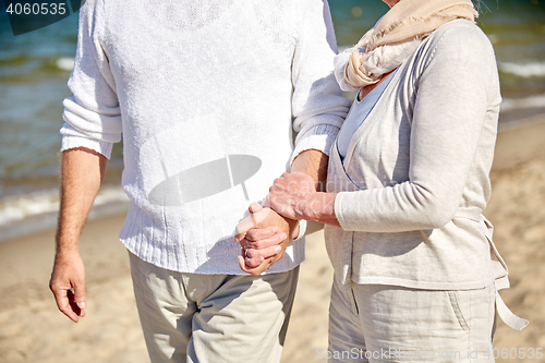 Image of close up of senior couple walking on summer beach