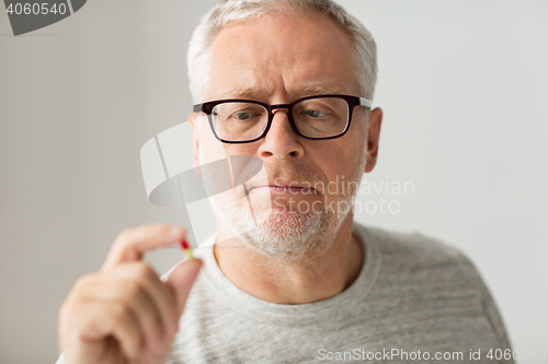 Image of close up of senior man taking medicine pill