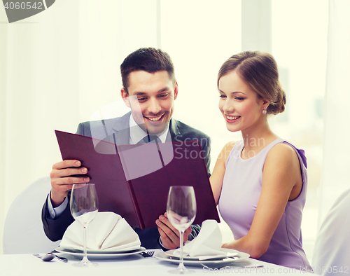 Image of smiling couple with menu at restaurant