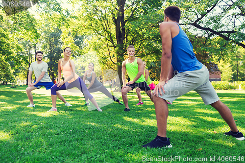 Image of group of friends or sportsmen exercising outdoors