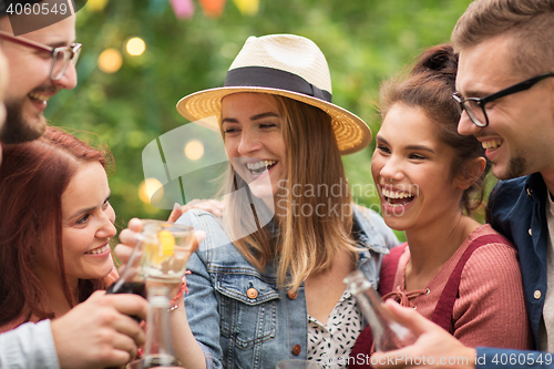 Image of happy friends clinking glasses at summer garden