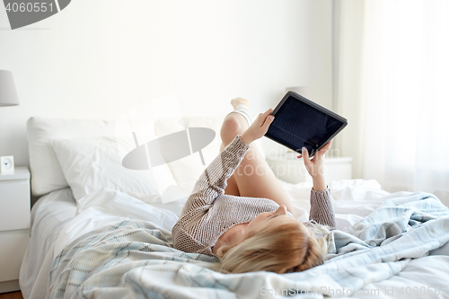 Image of happy young woman with tablet pc in bed at home