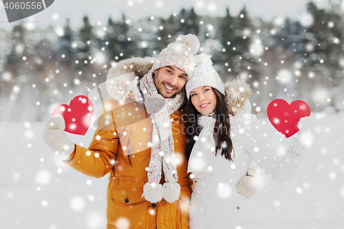 Image of happy couple with red hearts over winter landscape