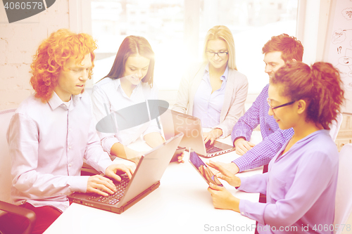 Image of smiling team with laptop and table pc computers