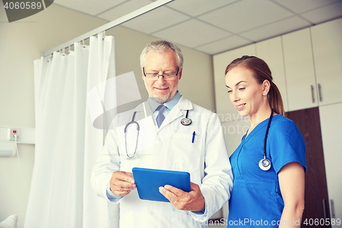 Image of senior doctor and nurse with tablet pc at hospital