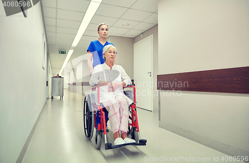 Image of nurse with senior woman in wheelchair at hospital