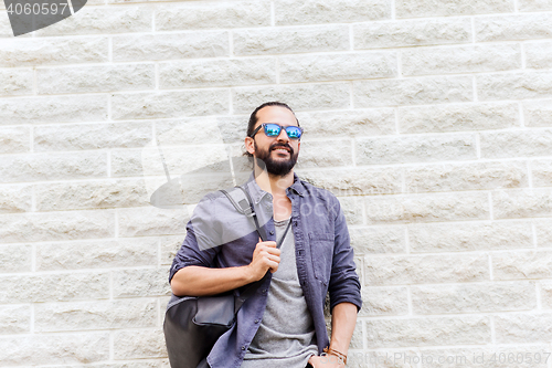 Image of man with backpack standing at city street wall