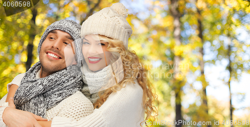 Image of happy couple in warm clothes over autumn