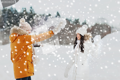 Image of happy couple playing with snow in winter