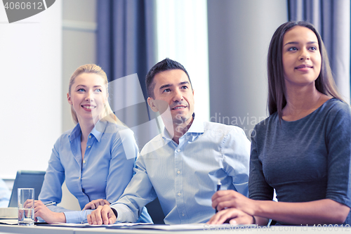 Image of group of smiling businesspeople meeting in office