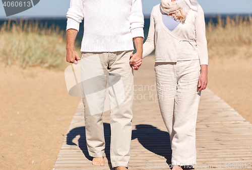 Image of close up of senior couple walking on summer beach