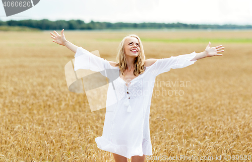 Image of smiling young woman in white dress on cereal field