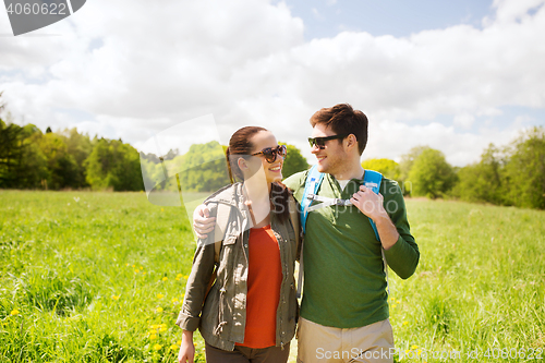 Image of happy couple with backpacks hiking outdoors