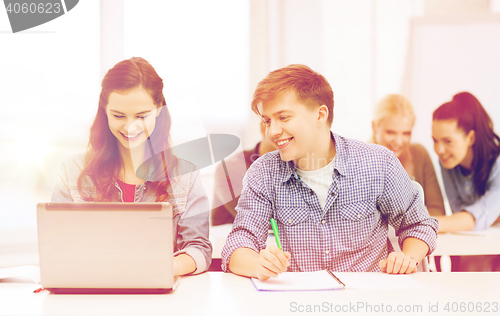 Image of students with laptop and notebooks at school