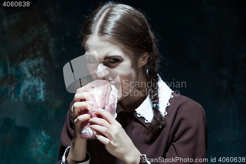 Image of Bloody Halloween theme: crazy girl with raw meat