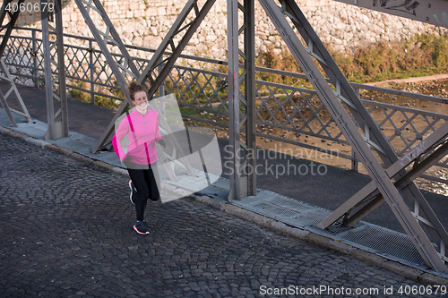 Image of sporty woman jogging on morning