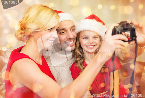 Image of smiling family in santa helper hats taking picture