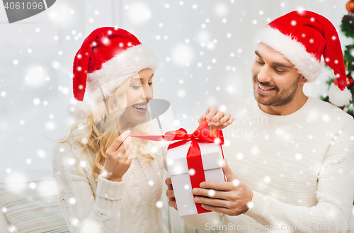 Image of happy couple at home with christmas gift box