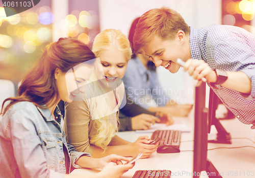 Image of students with computer monitor and smartphones