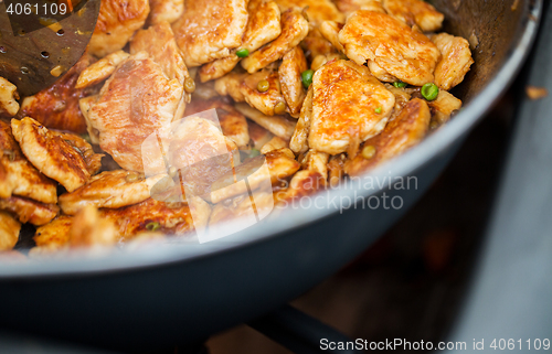 Image of close up of meat in wok pan at street market