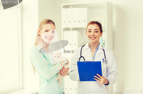 Image of happy woman with cat and doctor at vet clinic