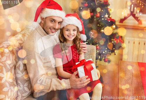 Image of smiling father and daughter holding gift box